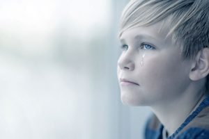 Teenager crying at a window