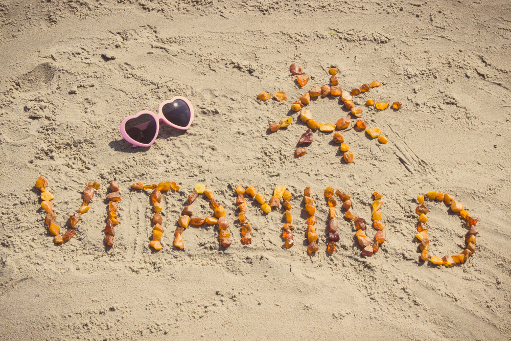 Vitamin D written in the sand with shells