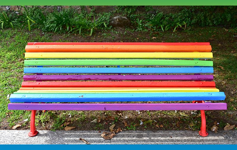 Park bench painted in rainbow pride