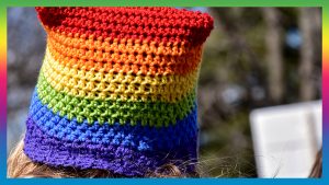 Woman wearing LGBT crocheted hat