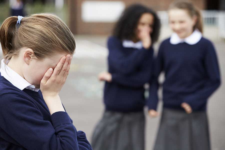 Young school covers her etes to hide her sadness at being bullied on the school playground