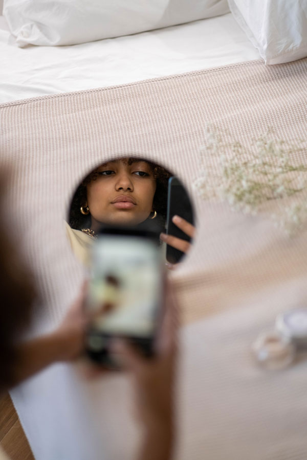 Girl's reflection in the mirror while looking at phone